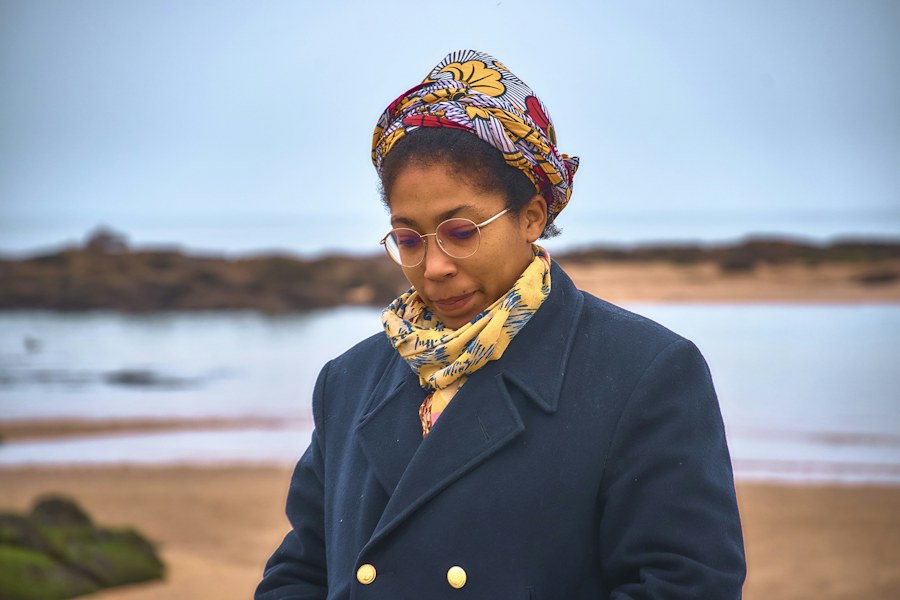Fashion model wearing a navy coat and colorful headwrap